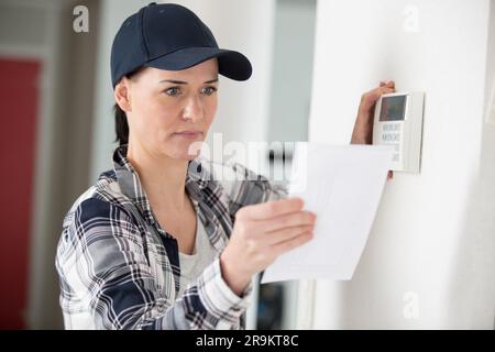 woman using smart wall home control system Stock Photo
