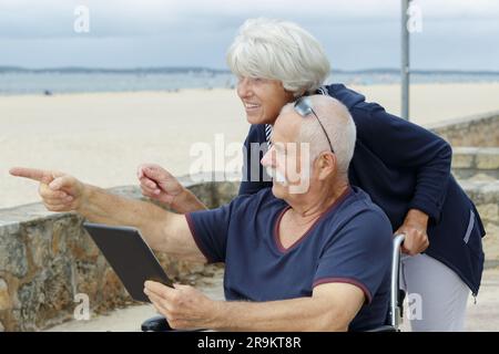 happy senior couple with tablet pc computer on the beach Stock Photo