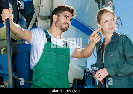 smiling man and woman farmer pointing at something Stock Photo