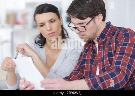 serious couple looking at paperwork together Stock Photo