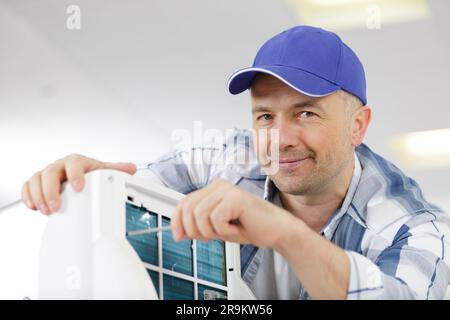 man assembling air conditioning unit Stock Photo