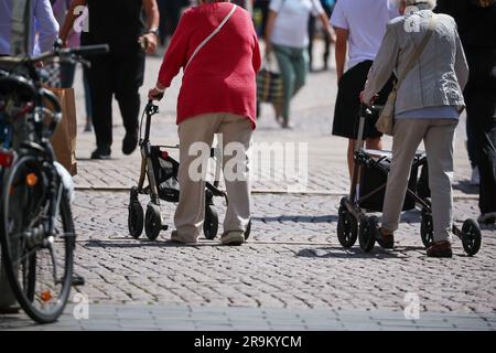 Leipzig, Germany. 27th June, 2023. Senior citizens walk through Leipzig's city center with their walkers. The approximately 21 million pensioners in the country will receive more money starting in July. With the annual pension adjustment, old-age pensions will rise by 4.39 percent in the west and 5.86 percent in the east. In addition, almost 30 years after reunification, the so-called pension value in the east will be brought into line with that in the west - one year earlier than planned. Credit: Jan Woitas/dpa/Alamy Live News Stock Photo