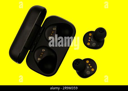 Wireless stereo earbuds. Black wireless earphones and charging case. Earbuds or headphones and charging case with bult-in rechargeable battery for the Stock Photo