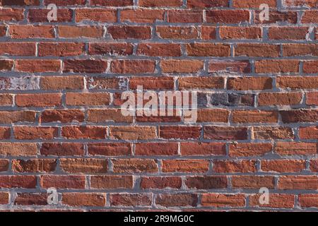 Red brick wall background with vintage bricks, mortar and abstract shapes and colours. Office backdrop. Stock Photo