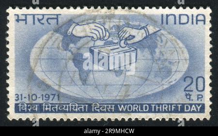 INDIA - CIRCA 1971: stamp printed by India, shows globe, hands, coins, circa 1971 Stock Photo
