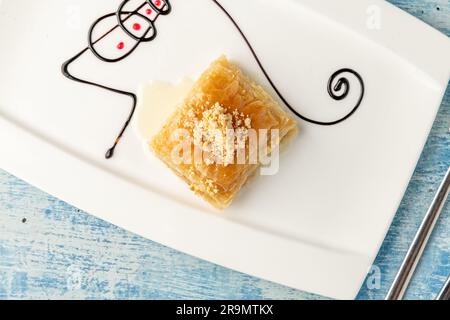 Turkish baklava with hazelnuts on a white porcelain plate Stock Photo