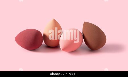 Multiple egg-shaped makeup sponges placed on a pink background. Stock Photo
