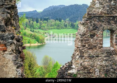 The ruins of the old castle with river and green hills in the background. Stock Photo