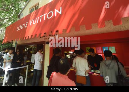SHANGHAI, CHINA - JUNE 28, 2023 - Sales staff line up canvas bags and books  with the Louis Vuitton brand LOGO at the entrance of a Louis Vuitton coffe  Stock Photo - Alamy