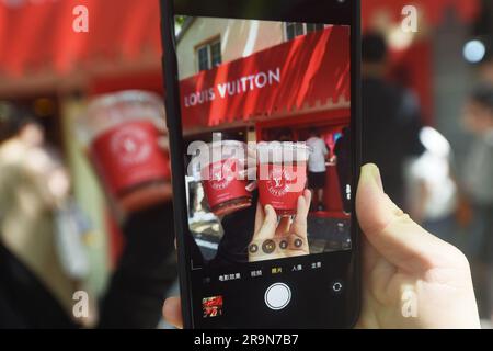 SHANGHAI, CHINA - JUNE 28, 2023 - People take photos of Louis Vuitton  coffee they just bought at the entrance of a Louis Vuitton cafe in  Shanghai, China, June 28, 2023. Recently