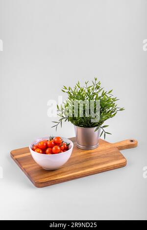 Red fresh Cherry Tomatoes on chopping boards and in a withe bowl Stock Photo