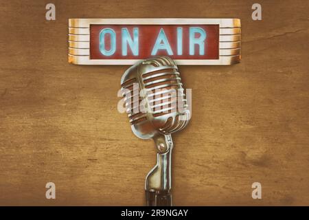 Retro styled image of an authentic vintage microphone with on air illuminated sign Stock Photo