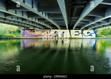 Contrasts. This image of graffiti by the Thames near Oxford does not show the traffic that - day and night - stream past on the bridge, carrying the c Stock Photo