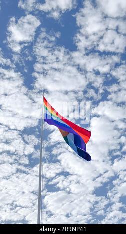 Cusco Flag Waving, Peru. Inka Rainbow flag of Cusco Peru blows in the wind on a blue sky day. Tahuantinsuyo flag Stock Photo