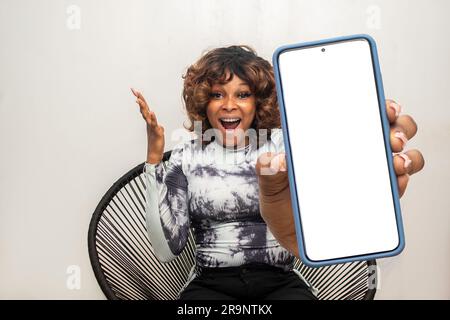 african lady showing a large phone screen looking surprised Stock Photo