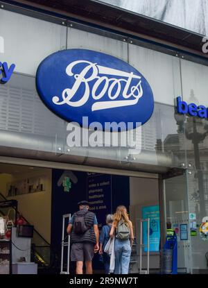 London, UK. 28th June 2023. Customers walk into the Boots store in Piccadilly Circus as the pharmacy and beauty products chain announces it will close 300 shops. Credit: Vuk Valcic/Alamy Live News Stock Photo