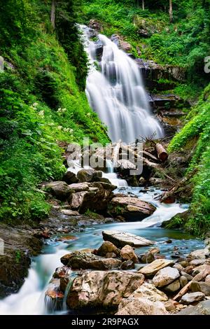 Waterfall cascade on mountain rocks. A mountain waterfall flows over the rocks. Deep rainforest waterfall view. Stock Photo