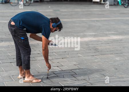 Kaiserslautern, Germany. 28th June, 2023. Artist at work on day 1. Eleven international artists from 6 countries are turning the Stiftsplatz (Square) pavement into three-dimensional art. 3D street art uses perspective to create optical illusion of space. Visitors are welcome to watch all artists at work over three days from Wednesday at 8:00 AM to Friday 6:00 PM. This years topic is 'Digitalisation and Smart City'. Paintings will depict robots, data, or cyberpunk scenarios. Credit: Gustav Zygmund/Alamy News Stock Photo