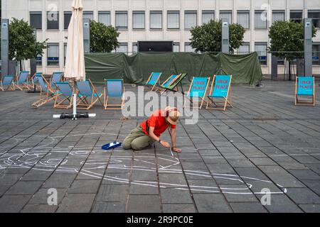 Kaiserslautern, Germany. 28th June, 2023. Maureen Kolhoff creating art on Stiftsplatz (Square). Eleven international artists from 6 countries are turning the Stiftsplatz (Square) pavement into three-dimensional art. 3D street art uses perspective to create optical illusion of space. Visitors are welcome to watch all artists at work over three days from Wednesday at 8:00 AM to Friday 6:00 PM. This years topic is 'Digitalisation and Smart City'. Paintings will depict robots, data, or cyberpunk scenarios. Credit: Gustav Zygmund/Alamy News Stock Photo