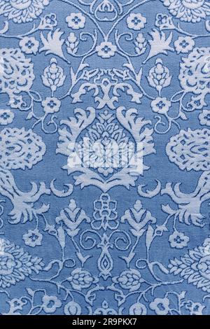 Fragment of retro tapestry textile pattern with handmade floral ornament in blue style. Stock Photo