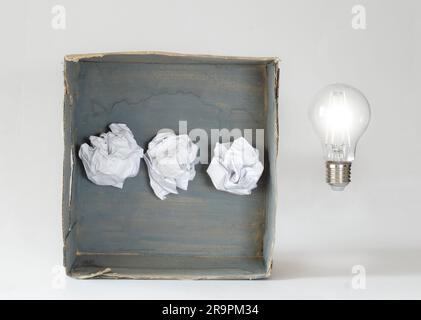 thinking outside the box,Innovation,idea,vision, business concept, grungy box with crumpled paper and light bulb, symbolic and meataphoric Stock Photo