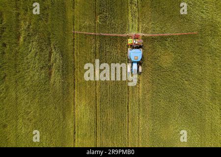 Aerial view of a tractor spraying agricultural fields. spraying herbicides on the field Stock Photo