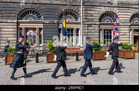 Soldiers marching in ceremony carrying flags at City Council Chambers to mark Armed Forces Day, Edinburgh, Scotland, UK Stock Photo