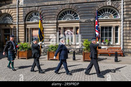 Soldiers marching in ceremony carrying flags at City Council Chambers to mark Armed Forces Day, Edinburgh, Scotland, UK Stock Photo