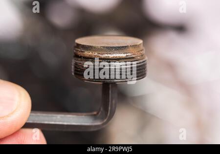 Bicycle brake pad on a hexagon in the hand of a bicycle maintenance master. Replacing old brake pads with new ones. Stock Photo