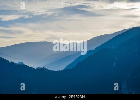 Sunset in the mountains. Dramatic colorful clouds over blue hills Stock Photo