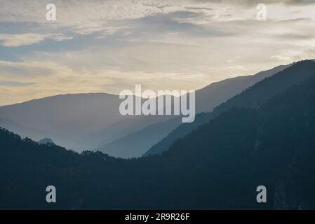 Sunset in the mountains. Dramatic colorful clouds over blue hills Stock Photo