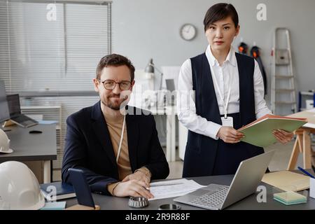 Portrait of two engineers, man and woman looking at camera in office Stock Photo