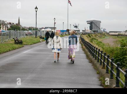 Two ladies deep in conversation as they stroll along the promenade, Lytham St Annes, Lancashire, United Kingdom, Europe Stock Photo