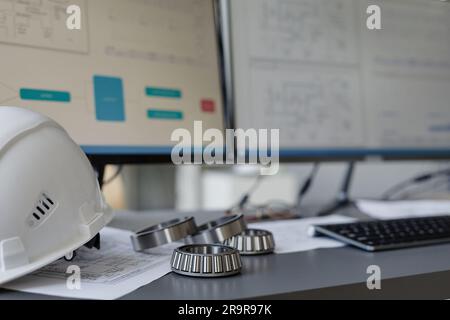 Closeup background image of steel mechanical parts on engineers workplace with blueprints, copy space Stock Photo