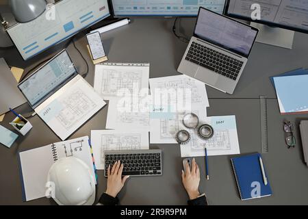 Wide angle top view at engineers workplace with blueprints and plans on computer desk, copy space Stock Photo