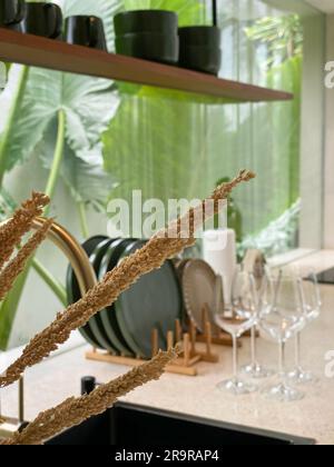 Dried decorative grass closeup with blured kitchen interior on on background Stock Photo