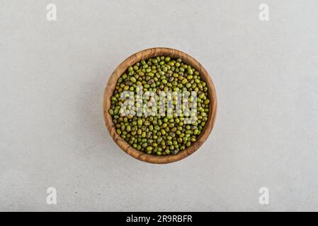 Dry raw organic mung beans in wooden bowl on concrete background. Top view Stock Photo