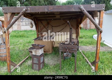 outdoor scene in horizontal view of the recreation of a blacksmith shop from the time of the ancient roman empire Stock Photo