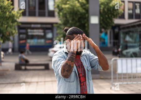 Kaiserslautern, Germany. 28th June, 2023. Mexican artist Mauricio Vargas preparing for a long summer day of work. Eleven international artists from 6 countries are turning the Stiftsplatz (Square) pavement into three-dimensional art. 3D street art uses perspective to create optical illusion of space. Visitors are welcome to watch all artists at work over three days from Wednesday at 8:00 AM to Friday 6:00 PM. This years topic is 'Digitalisation and Smart City'. Paintings will depict robots, data, or cyberpunk scenarios. Credit: Gustav Zygmund/Alamy News Stock Photo