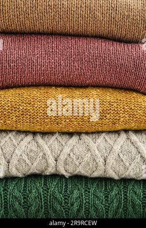 Pile of hand knitted winter clothes as background: sweaters, knitwear Stock Photo
