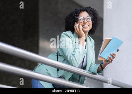 Portrait of positive african woman have phone conversation at office Stock Photo