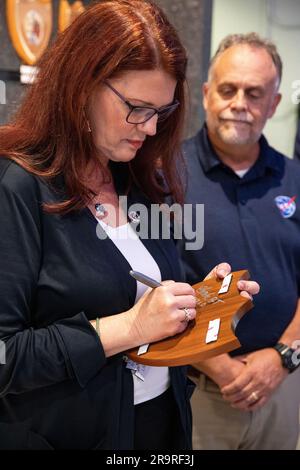 Artemis I Launch Director and Plaque Award Ceremony. Artemis Launch Director Charlie Blackwell-Thompson, at left, signs the back of the Artemis I plaque inside the lobby of the Launch Control Center at NASA’s Kennedy Space Center in Florida on March 24, 2023. Joining her is Shawn Quinn, manager, Exploration Ground Systems. Following tradition from the Apollo and Space Shuttle Programs, the plaque will be added to the wall behind them. The first in a series of increasingly complex missions, Artemis I launched successfully from Kennedy’s Launch Pad 39B at 1:47 a.m. EST on Nov. 16, 2022. Stock Photo