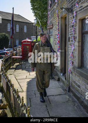 Haworth 1940's living history event (man patrolling & guarding, khaki WW2 Dad's Army costume, replica gas mask case kit) - West Yorkshire, England UK. Stock Photo