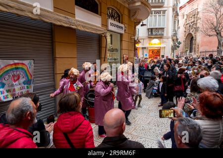 Malaga, Spain - FEB 27, 2022: People celebrating the Malaga Carnival with costumes, confettis, music, dance, marches and plays for kids in Malaga Stock Photo