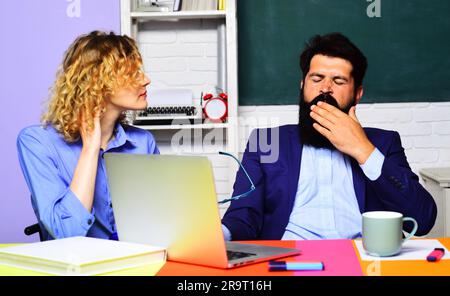 Teacher job. Male and female teachers in classroom. Tired overworked teachers or university professors at workplace. Fatigued students couple Stock Photo