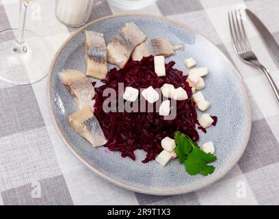 Sliced herring with grated beetroot and cheese served on table Stock Photo
