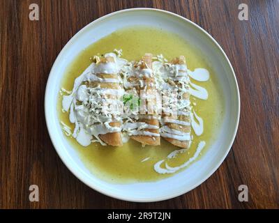 Green Enchiladas is a dish of Mexican cuisine made with rolled or folded corn tortillas and bathed in some spicy sauce with cream and cheese Stock Photo