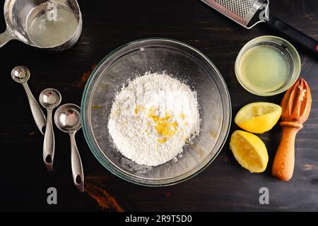 Mixing Bowl Filled with Sweet Lemon Glaze Ingredients: Glass mixing bowl with lemon glaze ingredients and kitchen tools Stock Photo