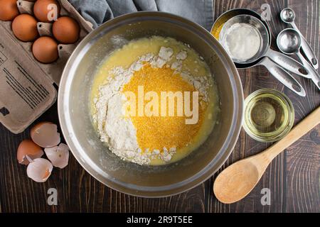 Buttermilk Cornbread Ingredients in a Mixing Bowl Viewed from Above: Coarse cornmeal, flour, eggs, and other ingredients for Southern cornbread Stock Photo