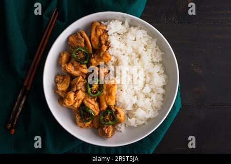 Crispy Hawaiian Garlic Chicken Served with Jasmine Rice: Fried chicken thighs in garlic-soy sauce served with fried jalapeno peppers and white rice Stock Photo